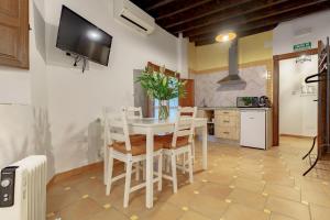 cocina y comedor con mesa blanca y sillas en SUITES CASA DE LAS COLUMNAS en Granada