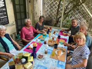 een groep mensen die rond een tafel eten bij Logis des Lauriers Roses in Marennes