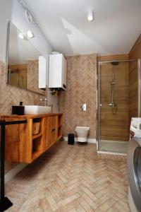 a bathroom with a sink and a shower and a toilet at Przytulny Apartament Słowackiego in Wągrowiec