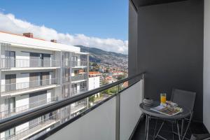 een balkon met een tafel en uitzicht op de stad bij Comfortable and near Funchal - Barreiros IV in Funchal