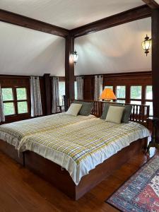 1 dormitorio con 1 cama grande en una habitación con ventanas en Ban MaeBo Local Stay en Ban Nong Han