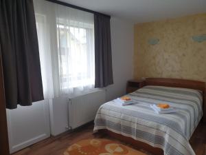1 dormitorio con 1 cama con 2 toallas en Pensiunea Vlahopol, en Pojorîta