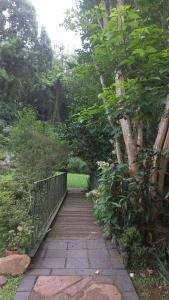 a walkway in a garden with a fence and trees at Me, myself, I Glamping in Pietermaritzburg