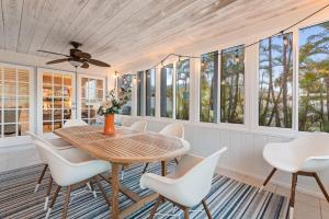 a dining room with a wooden table and white chairs at Siesta Key Oasis with Outdoor Pool and Screened Lanai! in Siesta Key