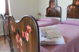 - une chambre avec 2 lits avec des draps roses dans l'établissement B&B La casa in campagna, à Fidenza