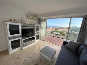 a living room with a couch and a large window at AlquilaEasy Eurosol in Torremolinos