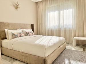 um quarto com uma cama grande e uma janela em Appartement face à la mer et à 10min du centre-ville em Casablanca