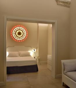 une chambre avec un lit avec un lustre au mur dans l'établissement Palazzo Rudiae - Sant'Irene, à Lecce