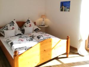 1 dormitorio con cama de madera y almohadas en Ferienwohnung zum Gimpei, en Siegsdorf