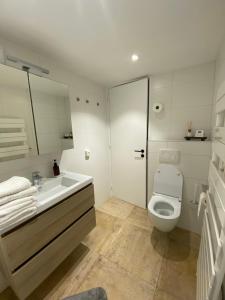 uma casa de banho branca com um WC e um lavatório em L’Oxymore em Waimes