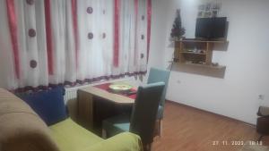 a living room with a desk and a table and a couch at Nevesinje centar Apartman in Nevesinje