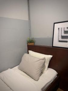 1 cama con almohadas blancas en una habitación en GRAYHAUS Guest House, en Petaling Jaya