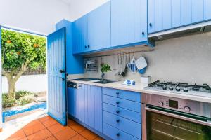 uma cozinha azul com um lavatório e um fogão em Comporta Sweet Home em Comporta