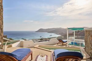 a patio with chairs and a swimming pool and the ocean at Arte & Mare Elia Luxury Suites and Villas in Elia Beach