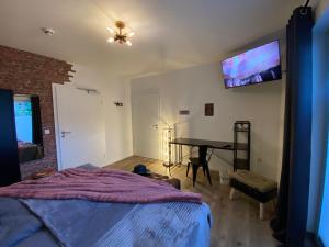 - une chambre avec un lit, une table et une télévision dans l'établissement Wild West Appartement, à Bad Salzuflen