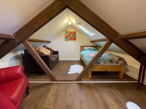 um quarto no sótão com uma cama e um sofá em Bridgend Cottage em Abercraf