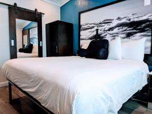 a bedroom with a white bed with a large painting on the wall at Signature Inn San Francisco Marina District in San Francisco