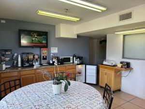 a kitchen with a table and a kitchen with a tv at Americas Best Value Inn and Suites Groves in Groves