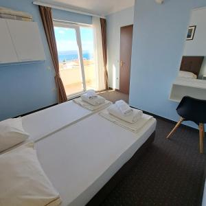 a hotel room with a large bed and a window at Apartments Vila Adrijana & Fitness Studio WOLF BV in Baška Voda