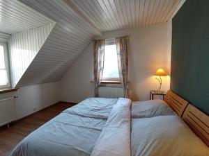 een slaapkamer met een groot bed op zolder bij Dachgeschoss - Maria von Berg - Wohnen auf Zeit in Rottweil