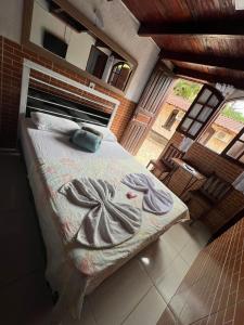 a bedroom with a bed with towels on it at Pesque pague pousada do Carlinho in Pinheiral