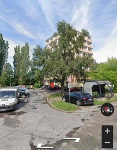 um parque de estacionamento com carros estacionados em frente a um edifício em CENTRAL APARTMAN 7 em Komárno