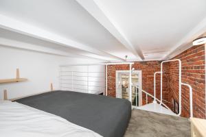 - une chambre avec un lit et un mur en briques dans l'établissement Unique Cosy Flat in Krakow Old Town, à Cracovie