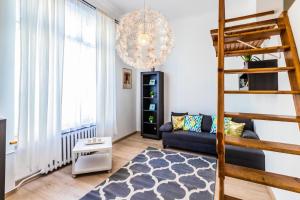 salon ze schodami i kanapą w obiekcie VIP Apartments - Apartamenty na Leszczyńskiego we Wrocławiu