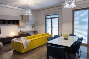 a living room with a yellow couch and a table at DimoraNOIDUE in Locorotondo