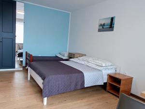 a bedroom with a bed and a blue wall at Pokoje Goscinne SALOMEA in Karwia
