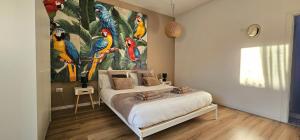 una camera da letto con un grande dipinto di uccelli sul muro di Casa Il sole, vicino Deruta Assisi Perugia Monte Falco a Deruta