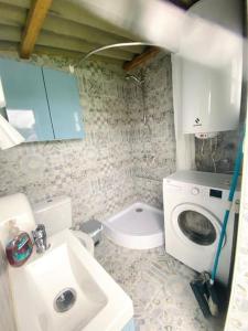 a bathroom with a toilet and a sink and a washing machine at Casa a la orilla del mar in Neda