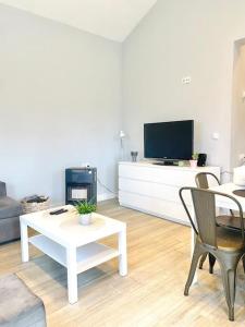 a living room with a tv and a table and chairs at Casa a la orilla del mar in Neda