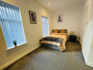 a bedroom with a bed and two windows at Luxury Double & Single Rooms with En-suite Private bathroom in City Centre Stoke on Trent in Stoke on Trent