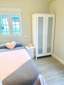 ein Schlafzimmer mit einem Bett mit einem Herzkissen drauf in der Unterkunft Casa a la orilla del mar in Neda