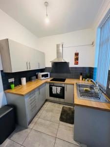 a kitchen with a sink and a stove top oven at Luxury Double & Single Rooms with En-suite Private bathroom in City Centre Stoke on Trent in Stoke on Trent