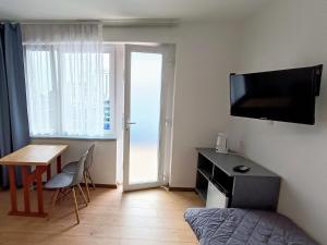 カルビアにあるPokoje Goscinne SALOMEAのベッド、デスク、テレビが備わる客室です。