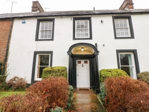 a white house with a black door at Cedars in Penrith