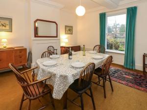 a dining room with a table with chairs and a mirror at Cedars in Penrith