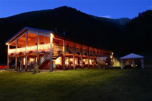 a large building with a staircase in a field at night at La Tresenda Hotel and Mountain Farm in Livigno