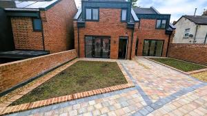 a brick house with a courtyard in front of it at Lovely Modernist 4 Bed House in Manchester