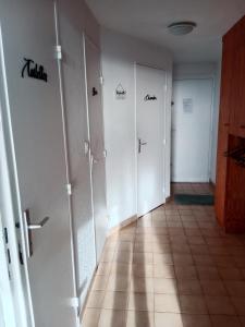 een hal met drie deuren en een tegelvloer bij Superbe appartement avec vue sur la mer et port in Frontignan