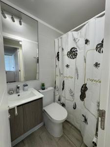 ein Badezimmer mit Toilette, Waschbecken und Duschvorhang in der Unterkunft Departamento La Serena in La Serena + 10 Fotos