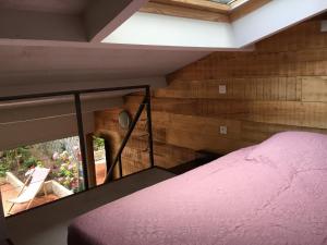 a bedroom with a pink bed and a window at Le Petit Paradis in Honfleur