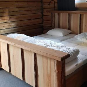 Habitación con 2 camas grandes y paredes de madera. en Ammeråns Fiskecamp en Hammarstrand