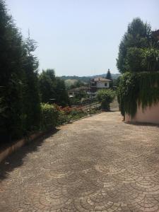 une route pavée dans une cour avec des arbres et des maisons dans l'établissement VILLA ISELLA, à San Venanzio