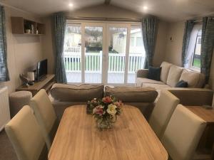 a living room with a table with flowers on it at Captivating 3-Bed brand new Luxury Caravan in Skipsea