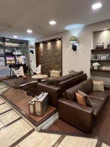 a living room with a brown leather couch at Hotel Alvear in Montevideo