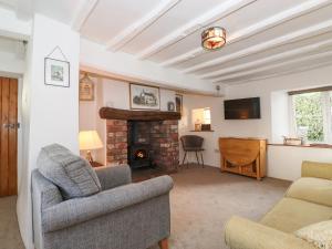 a living room with a couch and a fireplace at Jacky Garth Cottage in Keswick