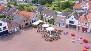 an overhead view of a street with a group of people sitting around tables at Hotel-restaurant "Lely" in Oude-Tonge